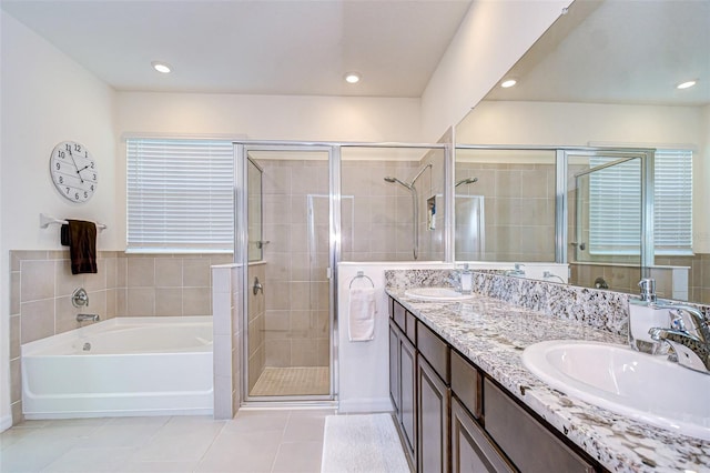 bathroom with a garden tub, tile patterned flooring, a sink, and a shower stall