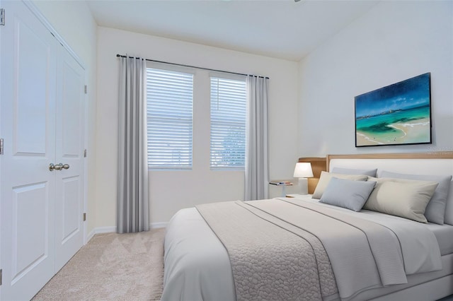 bedroom featuring light carpet and baseboards