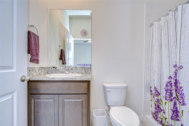 bathroom featuring a shower with shower curtain, vanity, and toilet