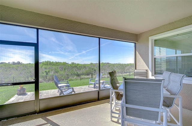 sunroom featuring a forest view