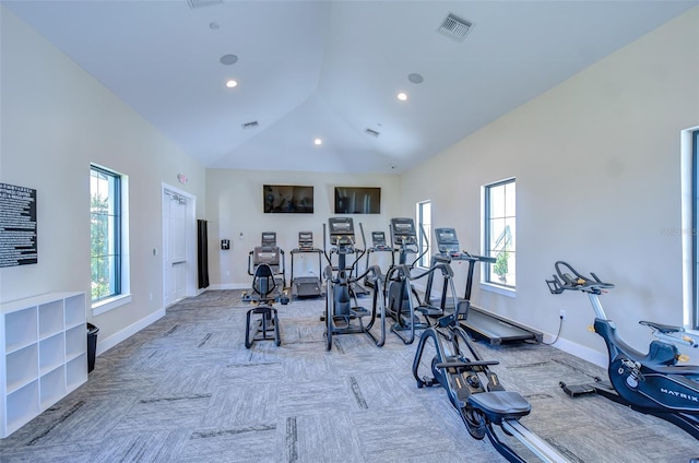 exercise room with high vaulted ceiling, baseboards, and visible vents