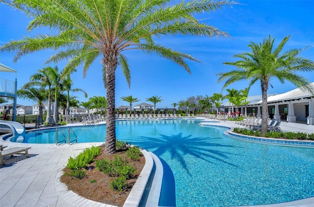 pool featuring a water slide and a patio