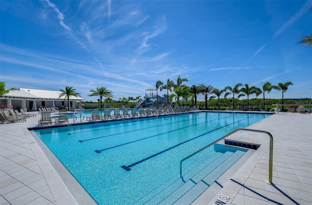 community pool with a patio area and a water view