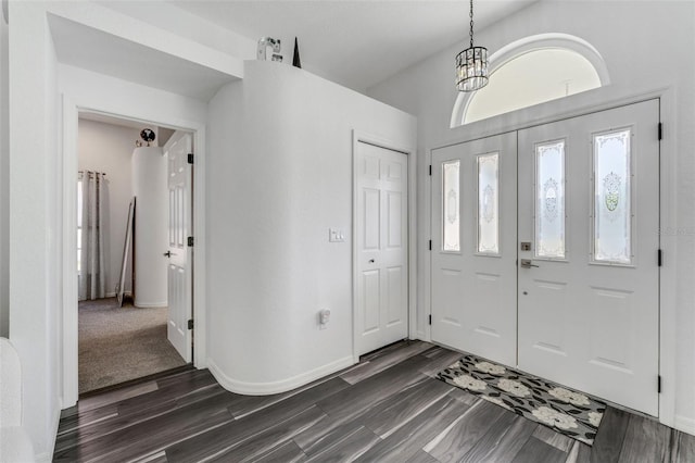 14247 Spanish Wells Dr, Hudson, FL 34667 - entryway featuring dark wood-style floors, a chandelier, and baseboards