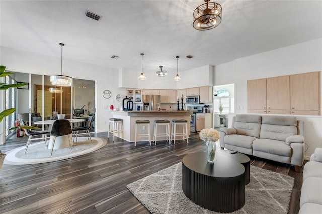 14247 Spanish Wells Dr, Hudson, FL 34667 - living area featuring dark wood-style floors, visible vents, and an inviting chandelier