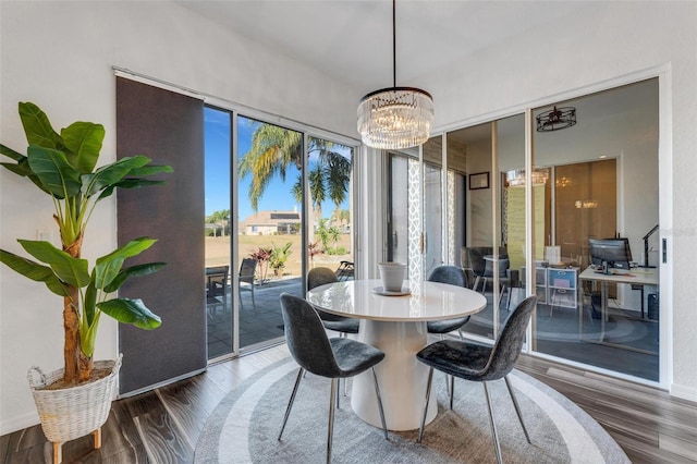 14247 Spanish Wells Dr, Hudson, FL 34667 - dining area featuring dark wood-style floors, baseboards, and a notable chandelier