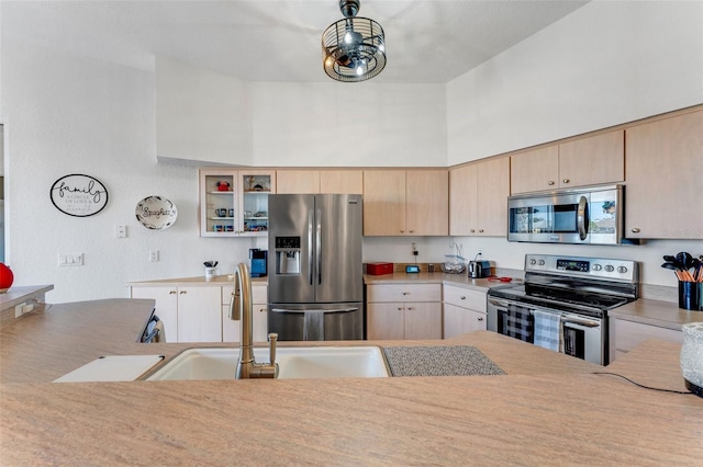 14247 Spanish Wells Dr, Hudson, FL 34667 - kitchen featuring glass insert cabinets, light countertops, stainless steel appliances, light brown cabinetry, and a sink
