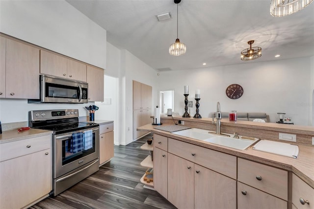 14247 Spanish Wells Dr, Hudson, FL 34667 - kitchen with appliances with stainless steel finishes, hanging light fixtures, light countertops, light brown cabinetry, and a sink