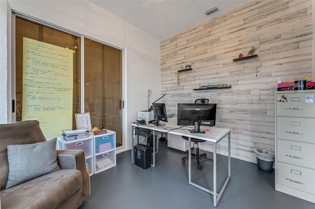 14247 Spanish Wells Dr, Hudson, FL 34667 - office area with finished concrete floors, visible vents, and wood walls