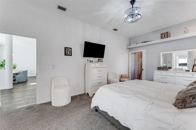 14247 Spanish Wells Dr, Hudson, FL 34667 - carpeted bedroom with baseboards, visible vents, and a notable chandelier