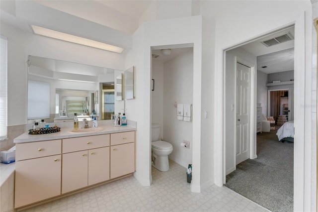14247 Spanish Wells Dr, Hudson, FL 34667 - ensuite bathroom featuring toilet, vanity, visible vents, tile patterned floors, and ensuite bath
