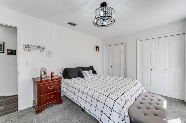 14247 Spanish Wells Dr, Hudson, FL 34667 - bedroom with two closets, visible vents, an inviting chandelier, carpet flooring, and baseboards