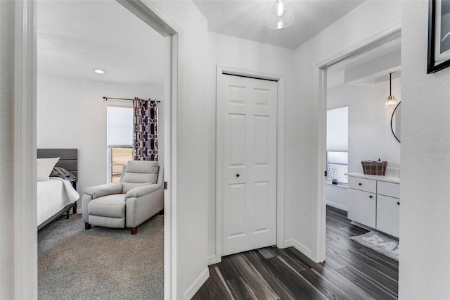 14247 Spanish Wells Dr, Hudson, FL 34667 - hall with a textured ceiling, dark wood-style flooring, and baseboards