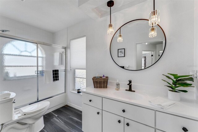 14247 Spanish Wells Dr, Hudson, FL 34667 - full bathroom featuring wood finished floors, combined bath / shower with glass door, vanity, and toilet