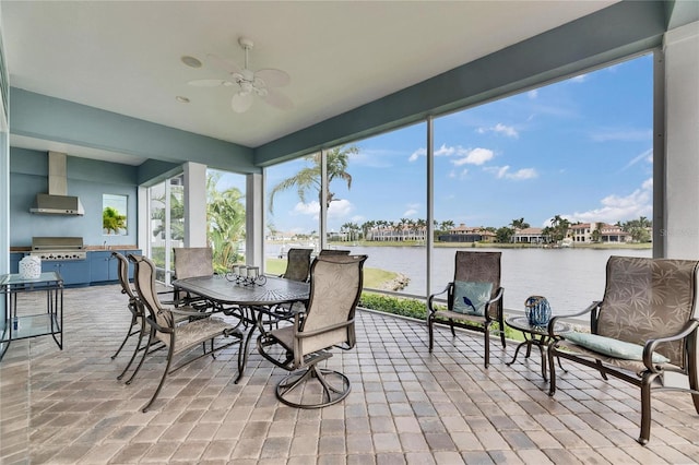 sunroom / solarium with a water view, a ceiling fan, and a wealth of natural light