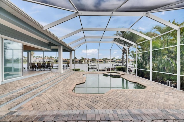 view of swimming pool with a lanai, a water view, a pool with connected hot tub, and a patio area