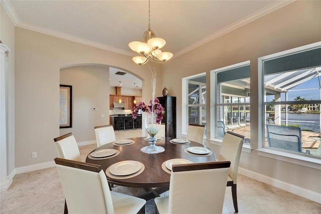 dining area with a water view, crown molding, baseboards, and a notable chandelier