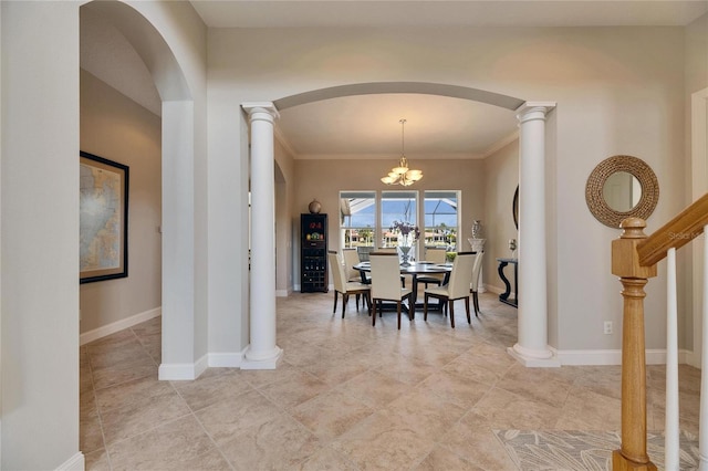 dining area with ornate columns, baseboards, and a notable chandelier