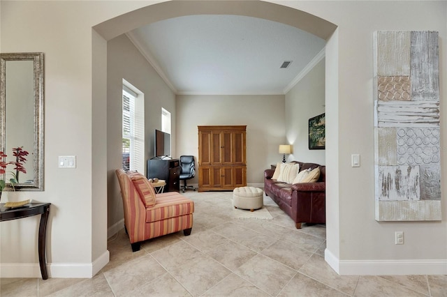 living area with baseboards, arched walkways, and ornamental molding