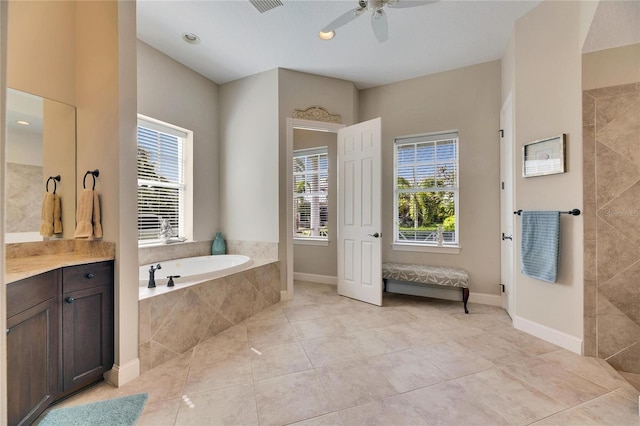 full bath featuring vanity, baseboards, a bath, and tile patterned floors