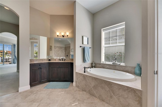 full bathroom featuring plenty of natural light, vanity, and a bath