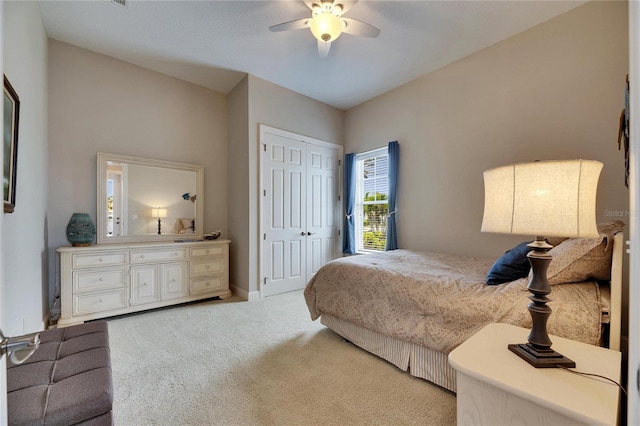 bedroom with a closet, a ceiling fan, and light colored carpet