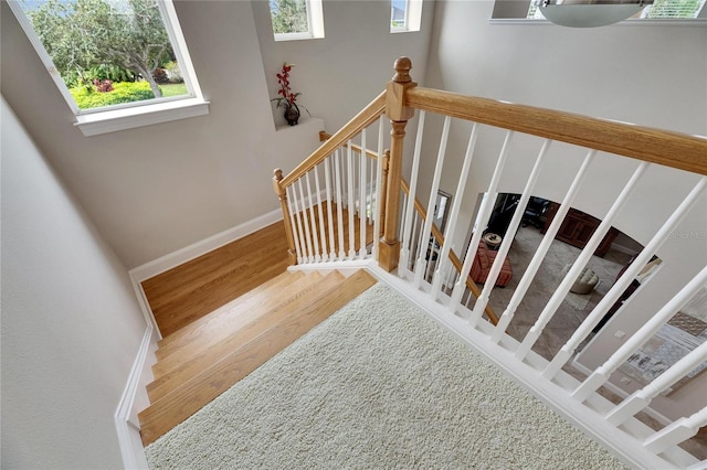 stairway with baseboards and wood finished floors