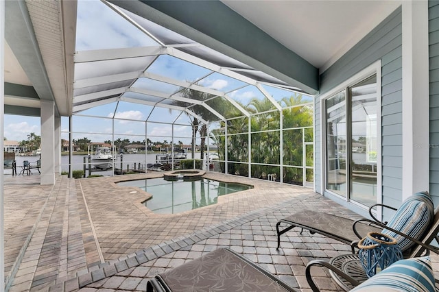 view of pool featuring a pool with connected hot tub, glass enclosure, a water view, and a patio