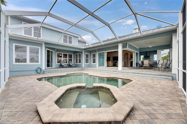 view of pool featuring ceiling fan, a patio, a pool with connected hot tub, and glass enclosure