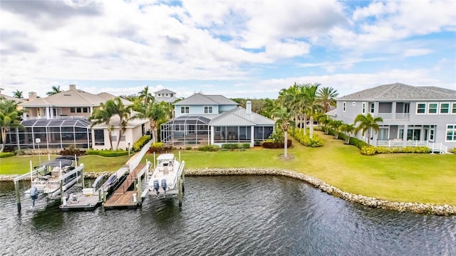 dock area with a lanai, a water view, boat lift, and a yard