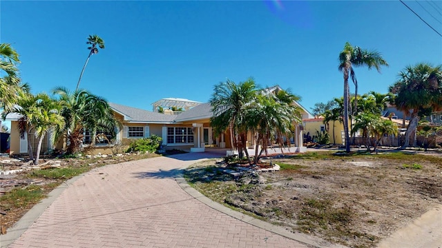 ranch-style house with decorative driveway and stucco siding