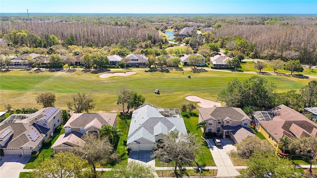 aerial view featuring view of golf course, a wooded view, and a residential view