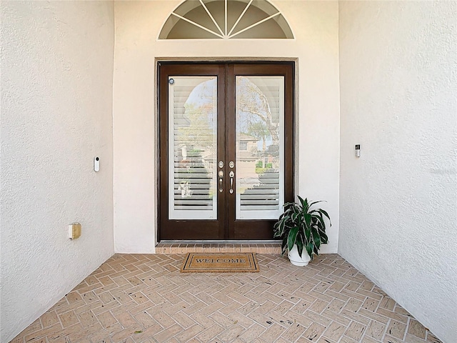 entrance to property with stucco siding and french doors