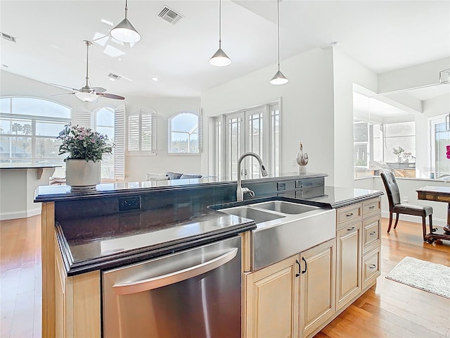 kitchen with dark countertops, visible vents, open floor plan, stainless steel dishwasher, and a sink