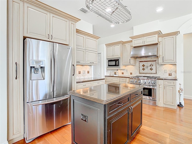 kitchen featuring visible vents, cream cabinetry, under cabinet range hood, appliances with stainless steel finishes, and light wood finished floors