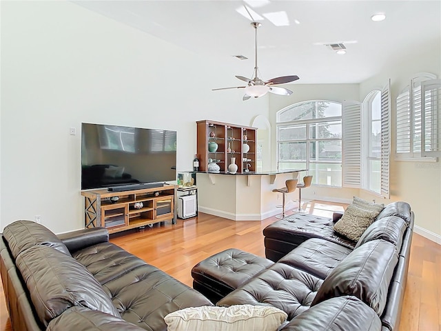 living room with a wealth of natural light, visible vents, wood finished floors, and ceiling fan