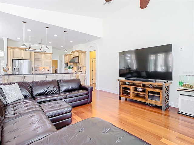 living room featuring visible vents, baseboards, light wood-type flooring, recessed lighting, and arched walkways