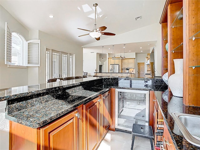 kitchen featuring visible vents, ceiling fan, wine cooler, lofted ceiling, and light tile patterned floors