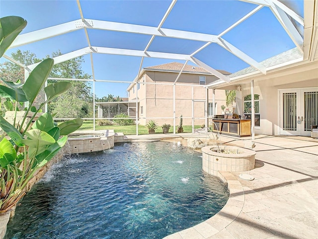 view of swimming pool featuring a pool with connected hot tub, french doors, glass enclosure, exterior kitchen, and a patio area