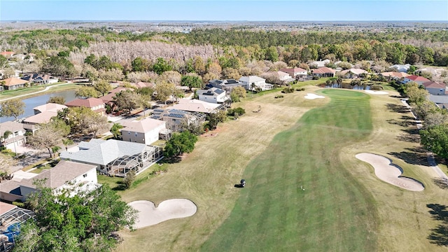 birds eye view of property with a residential view, a view of trees, a water view, and view of golf course