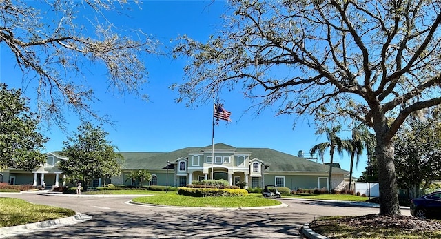 view of building exterior featuring curved driveway and fence