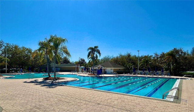 community pool with a patio and fence