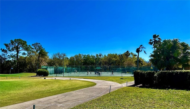 surrounding community with a tennis court, a yard, and fence