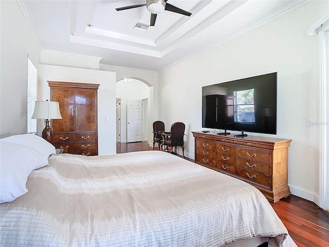 18111 Diamond Cove Ct, Tampa, FL 33647 - bedroom with dark wood-style floors, a tray ceiling, arched walkways, baseboards, and a ceiling fan