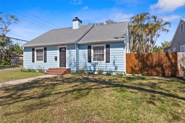 view of front of home featuring a shingled roof, a chimney, fence, and a front yard