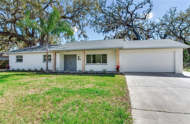 ranch-style home with concrete driveway, a front lawn, an attached garage, and brick siding