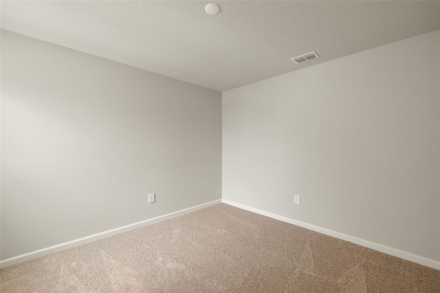 empty room with baseboards, a textured ceiling, visible vents, and carpet flooring