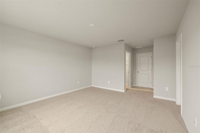 unfurnished room with light carpet, visible vents, and baseboards