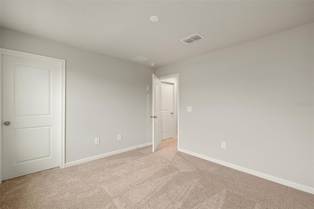 unfurnished bedroom featuring baseboards, visible vents, and light colored carpet