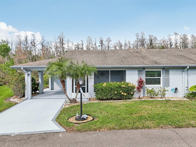 view of front of house with driveway, roof with shingles, a front yard, and stucco siding